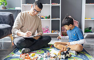 Vater und Sohn sitzen auf Spielteppich